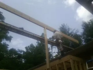 Carpenter setting a ridge beam over a new addition frame — Ice Dam Removal by Roofing Brothers in Manilla