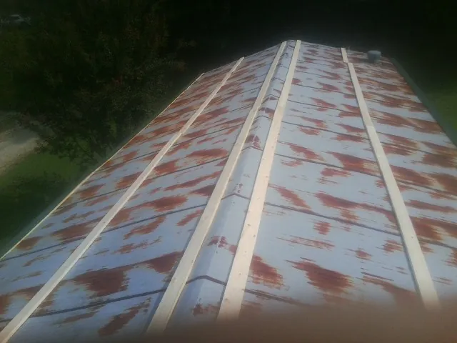 Rusted metal roof panels with new wood purlins before replacement — Storm Damage Roof Repair in Manilla by Roofing Brothers